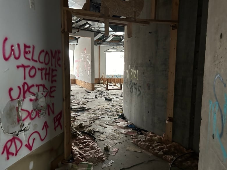 A corridor with trash all over the floor.