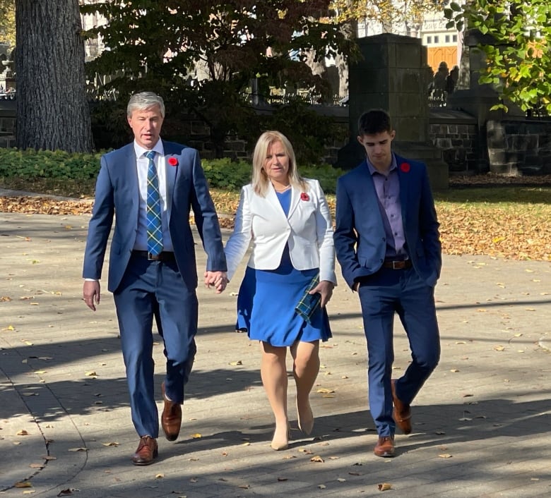 PC Leader Tim Houston is shown with his wife and son. All three are wearing clothes that feature the colour blue.