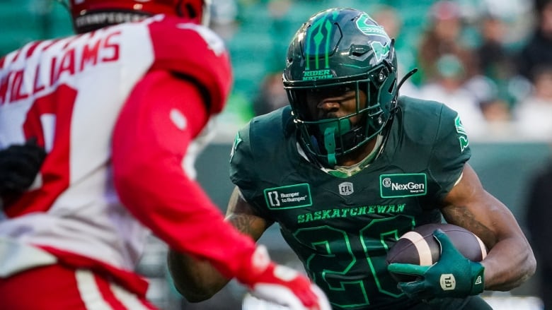 A football player faces off another carrying the ball.