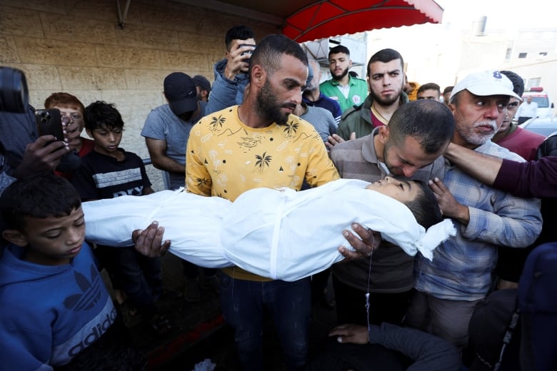 Mourners react next to a body of Palestinian child who was killed in Israeli strikes, amid the Israel-Hamas conflict, at Al-Aqsa Martyrs Hospital in Deir Al-Balah, in the central Gaza Strip, October 29, 2024. 