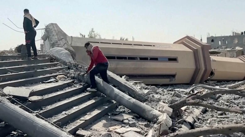 People observe a mosque destroyed by Israeli airstrikes in the city of Khan Younis, sothern Gaza Strip.