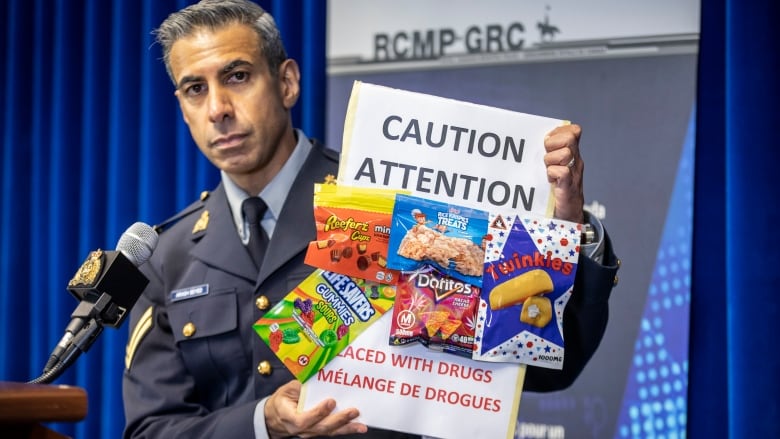 A man holds up fake candy.