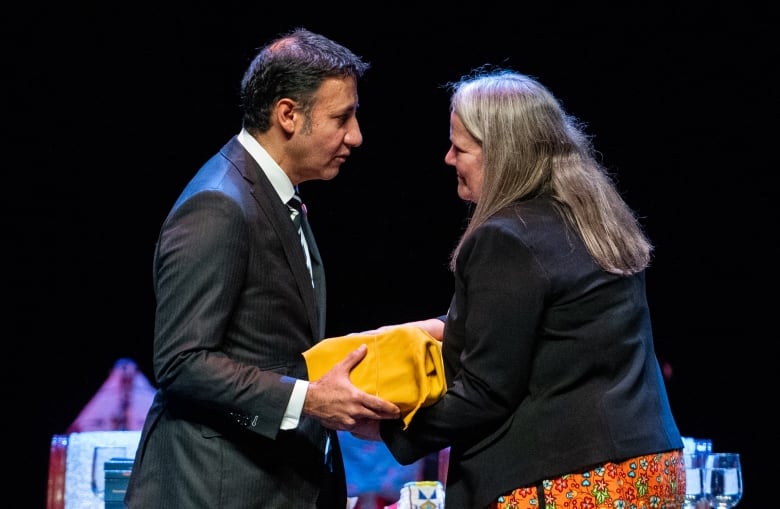 Minister of Justice and Attorney General of Canada Arif Virani, left, receives a report by Independent Special Interlocutor for Missing Children and Unmarked Graves and Burial Sites associated with Indian Residential Schools during a national gathering in Gatineau, Que., Tuesday, Oct. 29, 2024. 