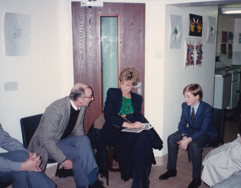 Two adults and a child talk while seated.