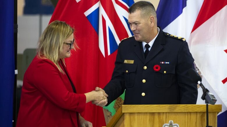 A man and woman shake hands.