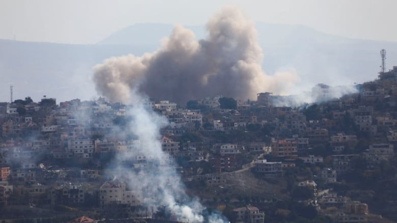 Smoke billows over a town.