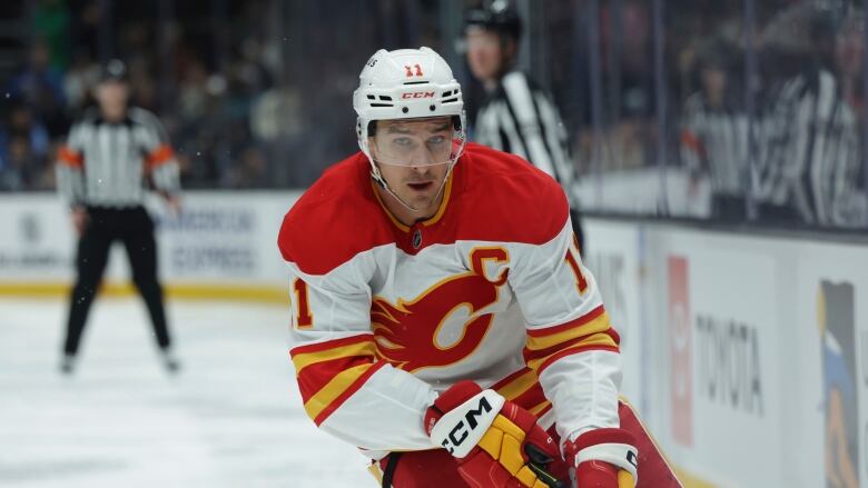 A man wearing hockey equipment and the white and red Calgary Flames team kit.