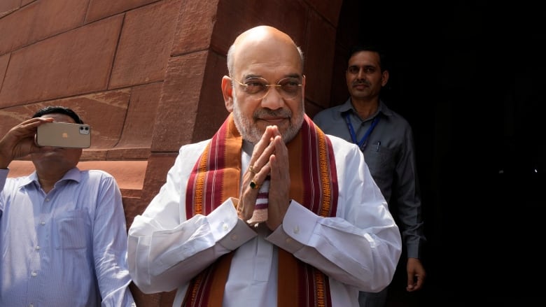 Indian Home Minister Amit Shah holds his hands together.