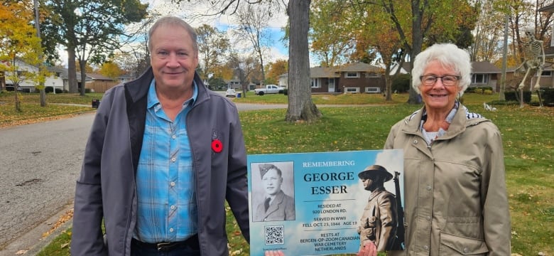 Jennie Kapteyn and her son Ray hold a sign George Esser. He died in the Netherlands in WW II and was Jennie's brother and Ray's uncle.