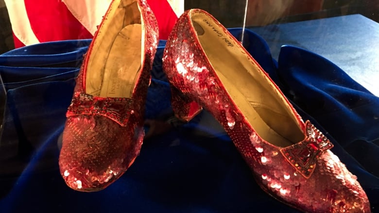 A pair of glittering red shoes are shown. 