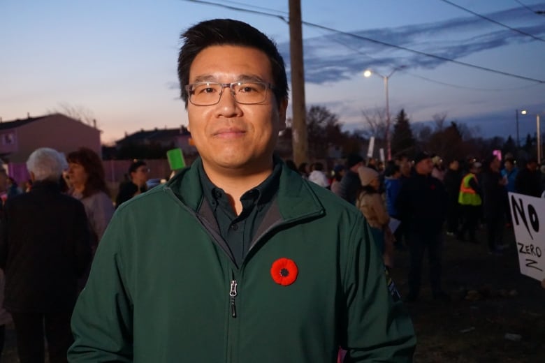 A man in front of a crowd at dusk