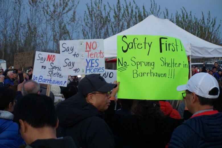 A protest crowd, people holding signs