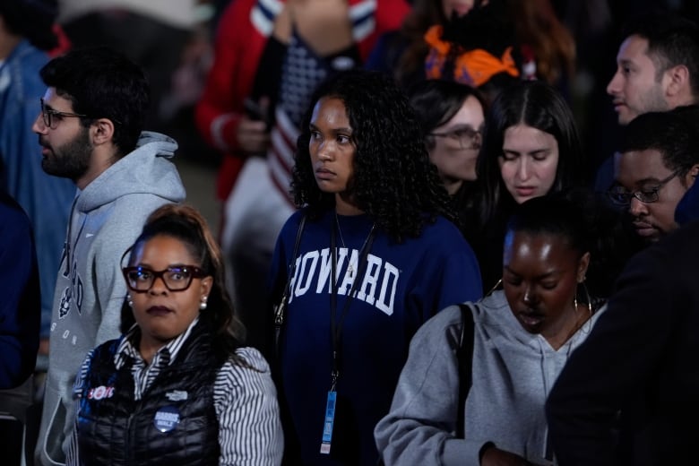 Several people of diverse backgrounds are shown standing, looking concerned or sad.