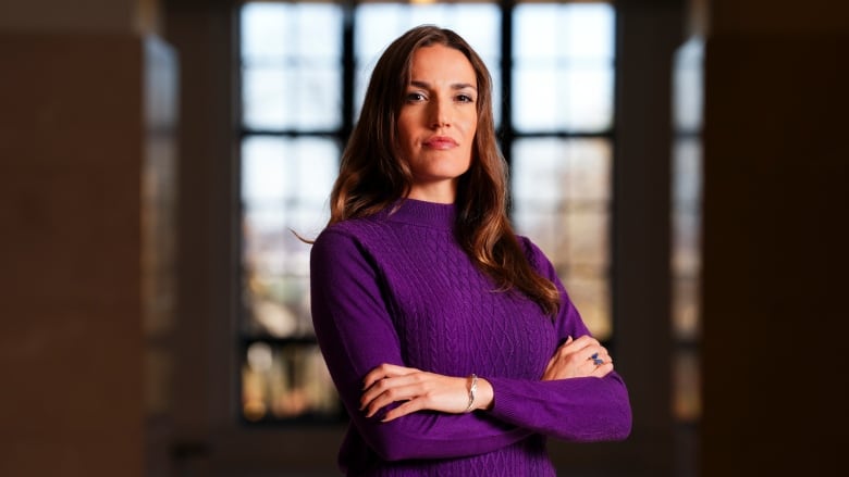 A portrait of a woman wearing a purple sweater.