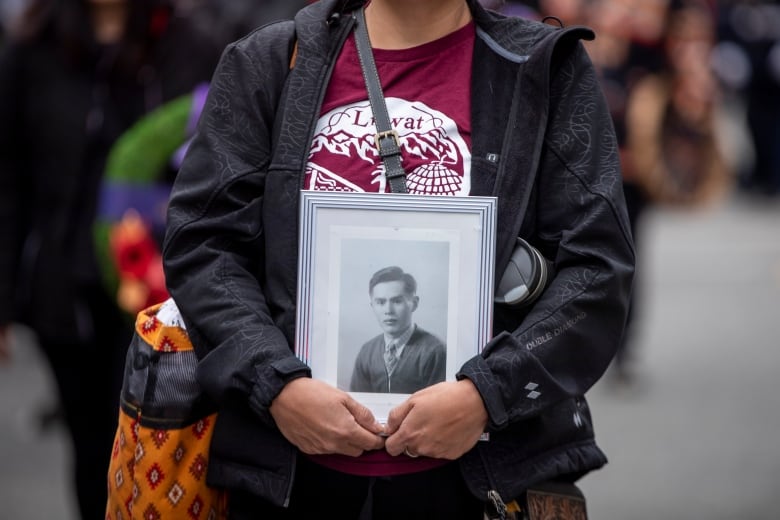 Ivy Joseph carries a photograph of her relative Joseph Joseph III, a WWII veteran from the Lil'wat Nation.