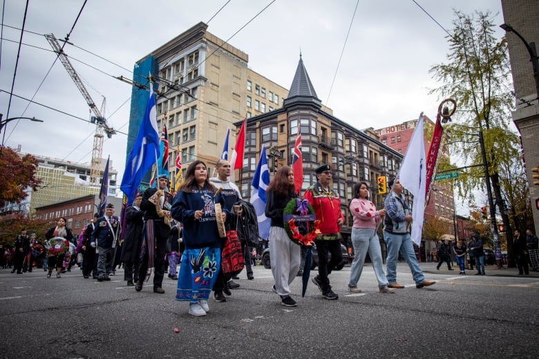 Veterans and spectators are pictured marching down East Hastings Street on National Indigenous Veterans Day.