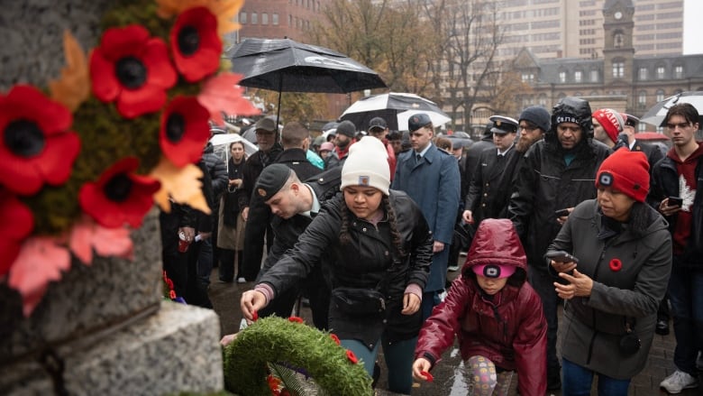 People placing their poppies at the cenotaph during Remembrance Day. 