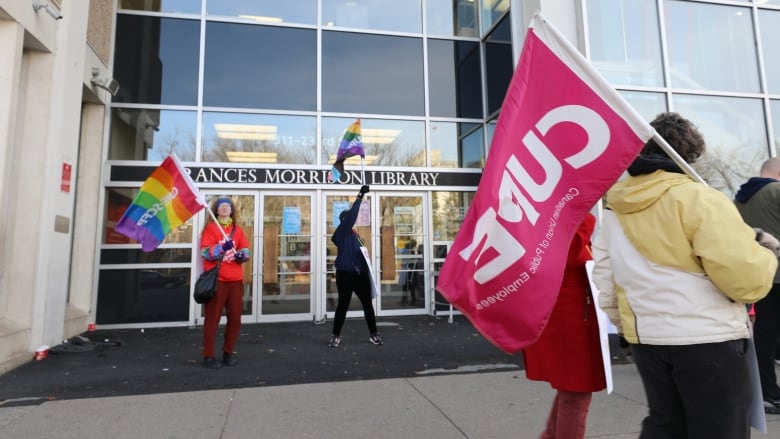 people are waving flags outside of a building 