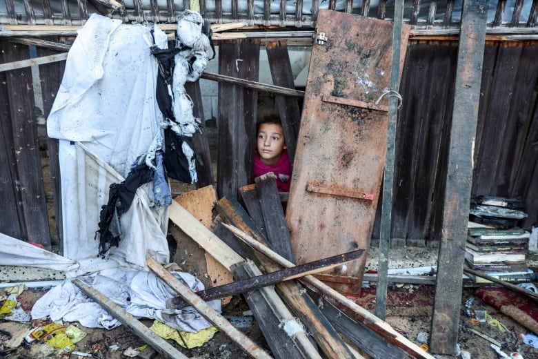 A child peaks out of debris.