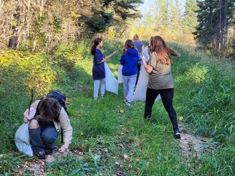 School children are out on the lands, forest area, to learn about what plants are on the lands.