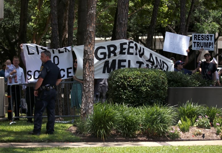 Protesters hold up signs agains the climate policy of President Donald Trump during his previous term in 2018.