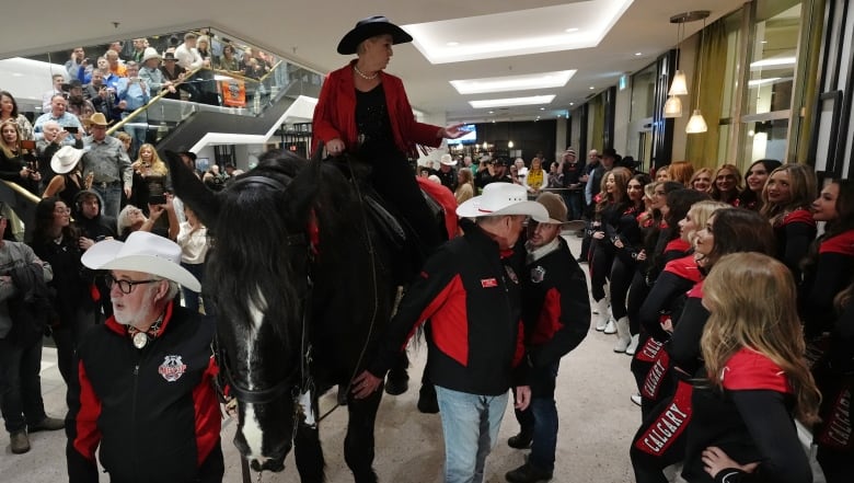 A woman rides a horse into the lobby of a hotel in downtown Vancouver.