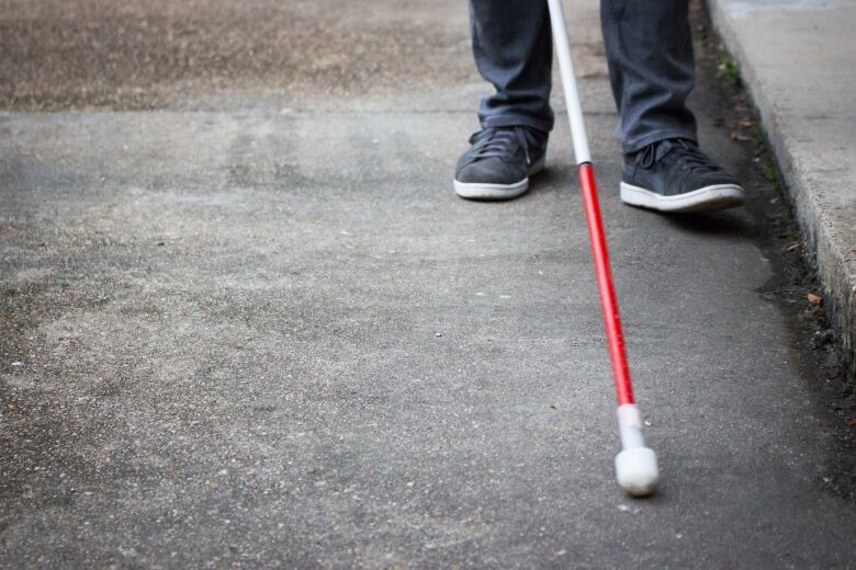 blind person walking with cane