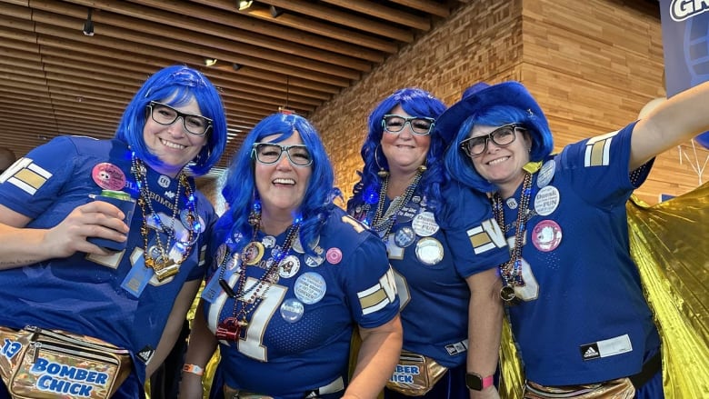 Four women dressed in blue and gold are ready to party.