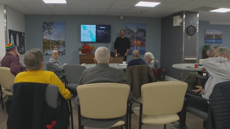 Man presenting in front of people. 