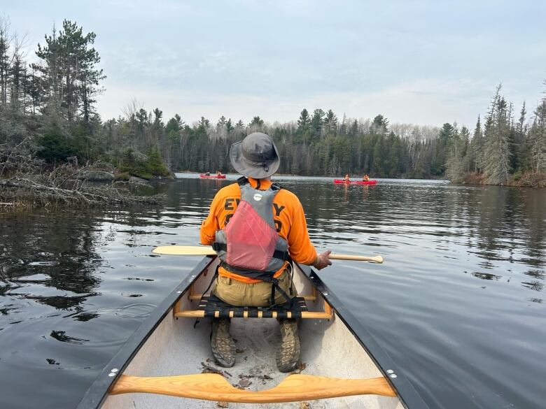 A man on a canoe on a river.