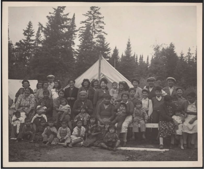 A black and white photo of a large group of people gathered outside.