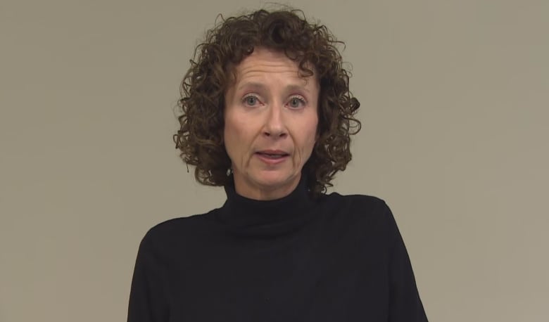 A woman with curly hair and a black turtleneck