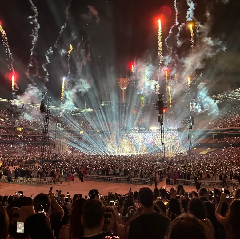 An arena with a stage shooting off fireworks