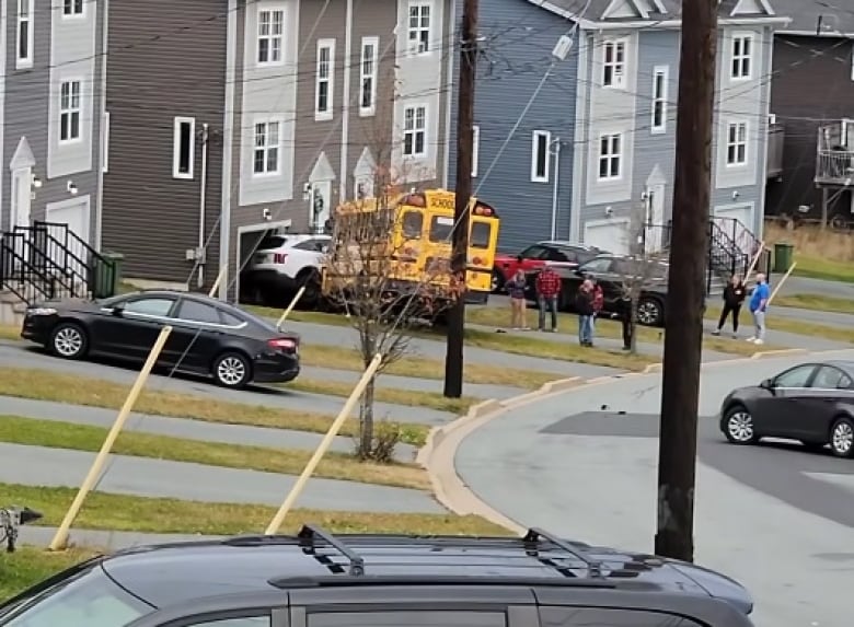 A yellow school bus crashed into a white car in front of a home. 