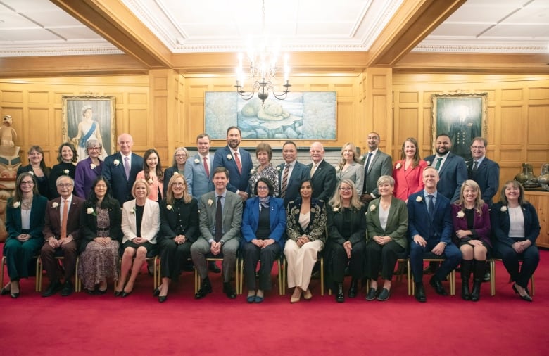 Two rows of people smile for a picture.