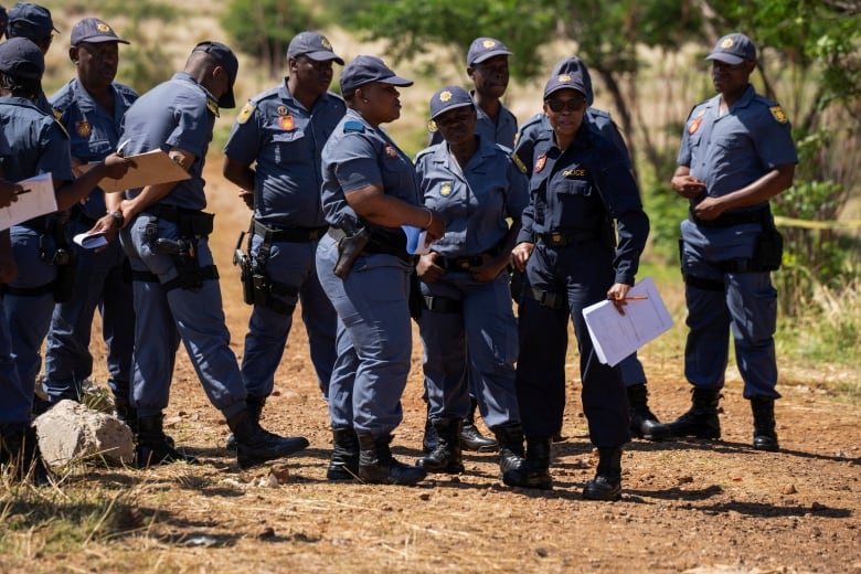 Police in blue uniforms stand outside 