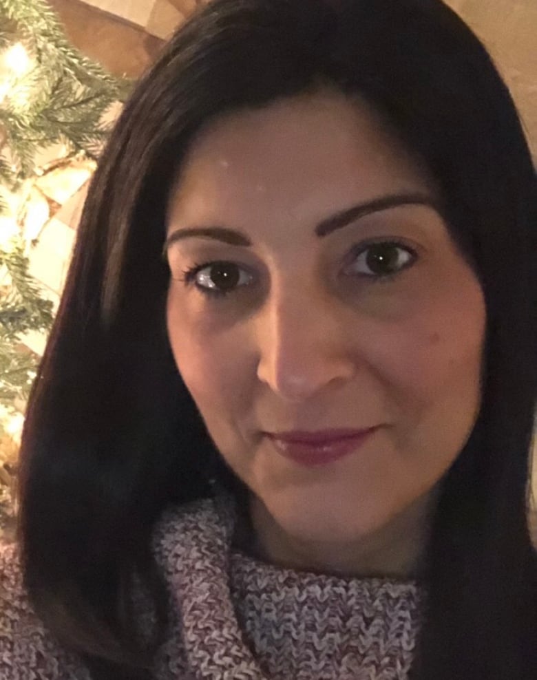 A profile picture of a woman sitting in a living room, with a Christmas tree in the background.