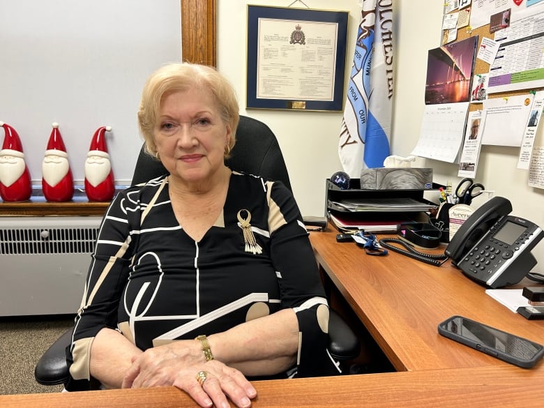 A woman sits at a desk in an office