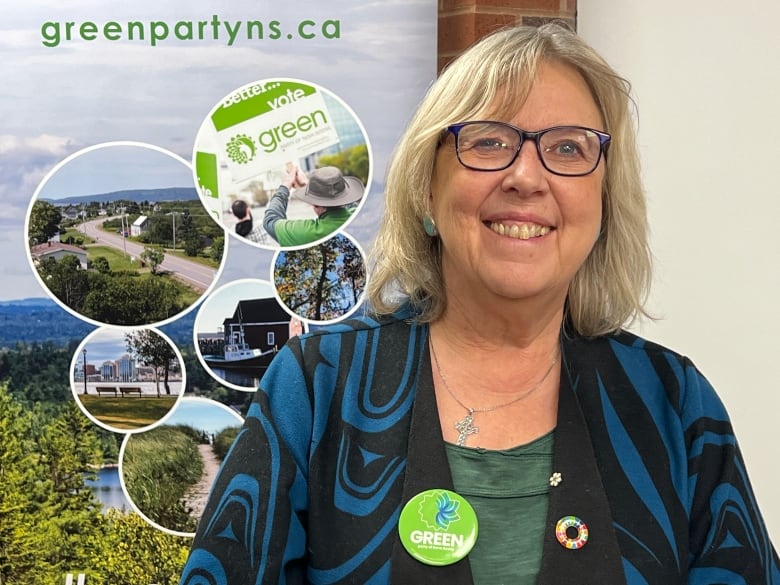 Elizabeth is smiling in front of a party poster. 