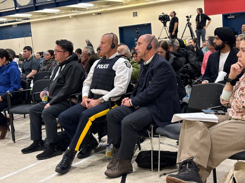 Two RCMP staff sitting amongst crowd