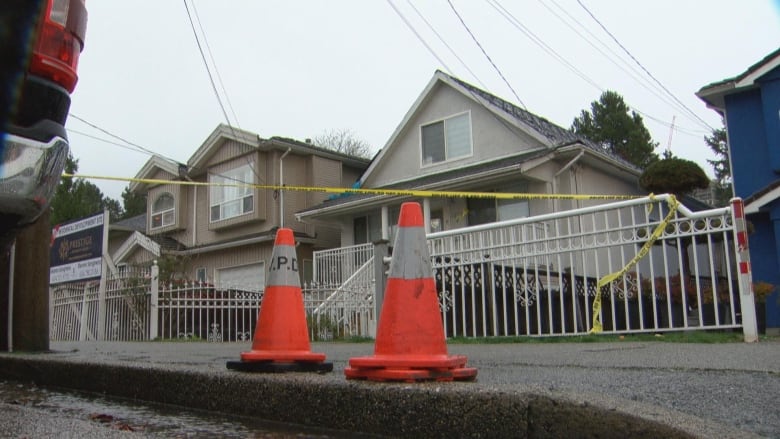 Crime tape surrounds a single-family house.