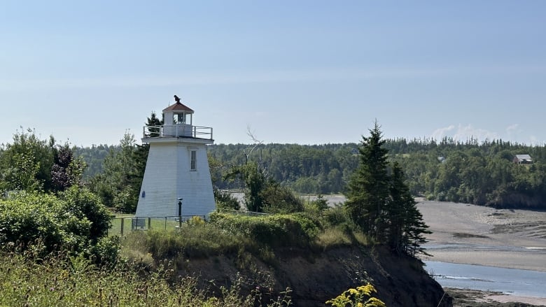 A white lighthouse at a cliff. 